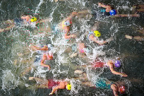 Athletes compete during swim leg of the triathlon competition